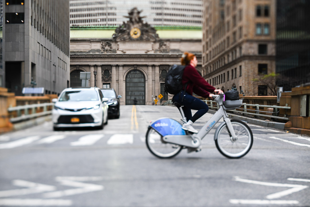 A cyclist rides across the street in front of Grand Central Terminal
