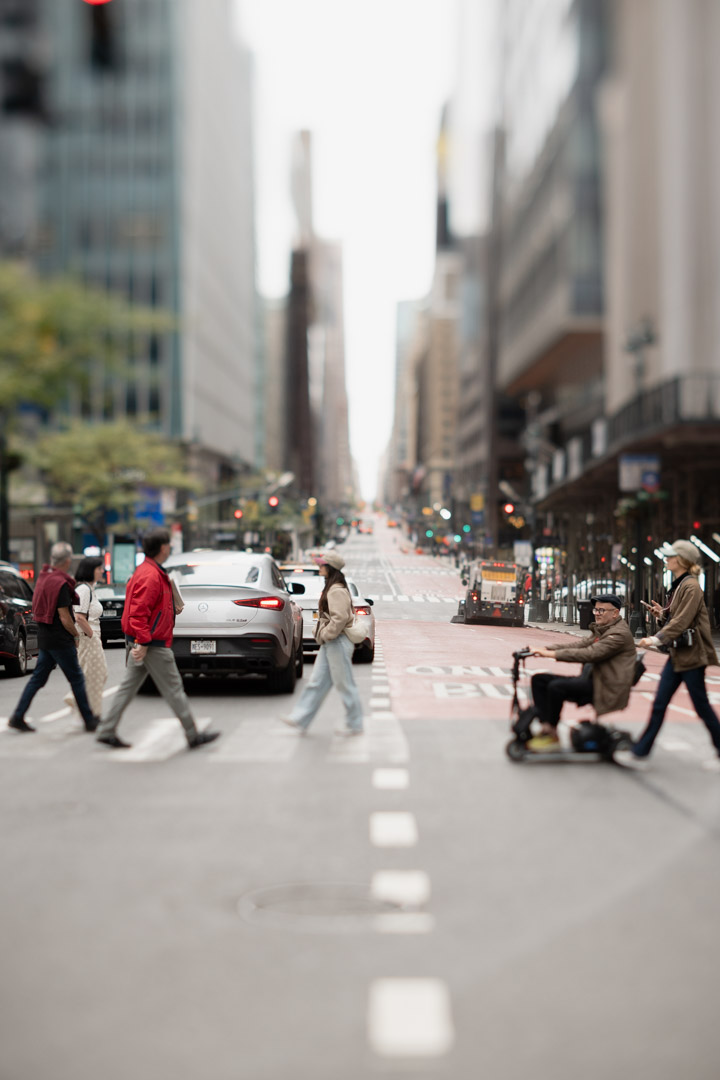 Pedestrians cross a busy Manhattan avenue